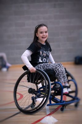 Girl with complex care needs smiling in wheelchair
